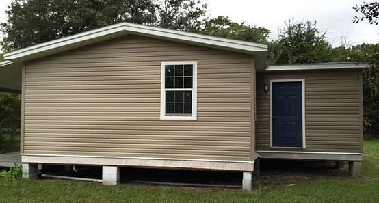 A house with a porch and windows in the middle of it.