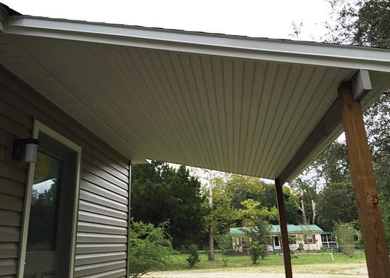 A house with a covered patio in the middle of it.