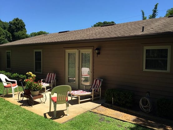 A patio with chairs and tables outside of the house.