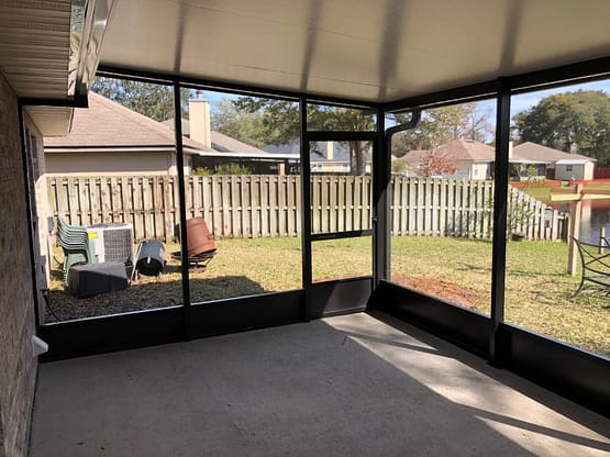 A room with glass walls and a patio.