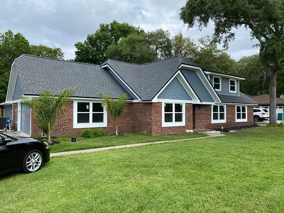 A large brick house with a car parked in front of it.