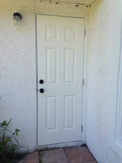 A white door with six panes and two black knobs.