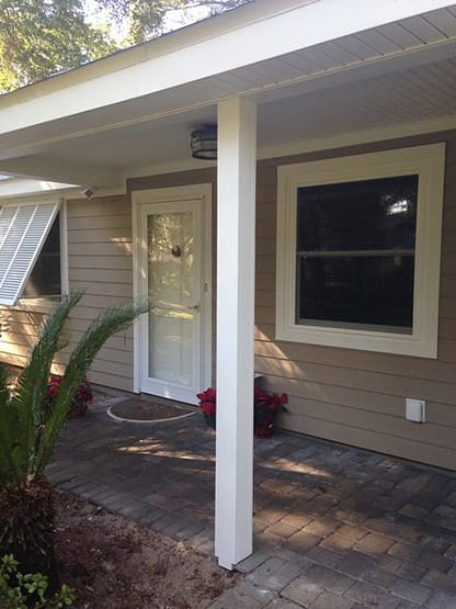 A porch with a white door and windows.