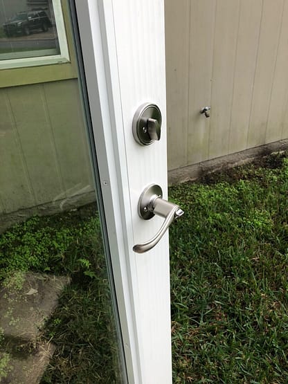 A white door with two locks and one key.