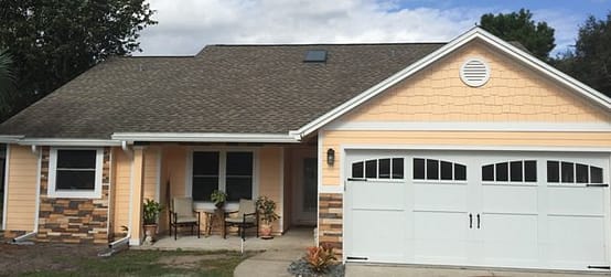 A house with a garage door and a porch.