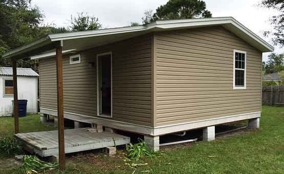 A small house with a porch and a deck.