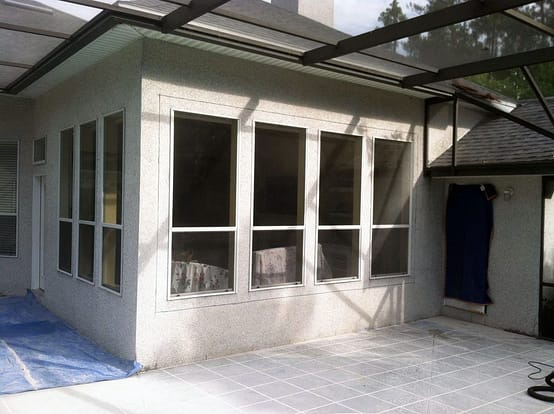 A white building with windows and a blue door.