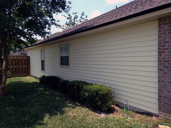 A house with a white wall and brown roof.