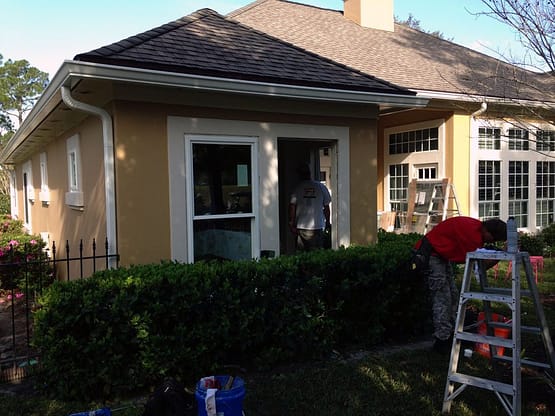 A man is painting the house yellow.