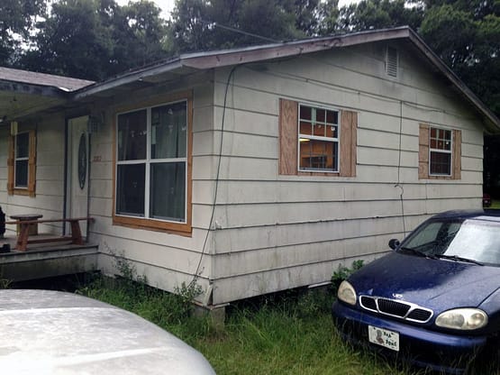 A house with a car parked in front of it.