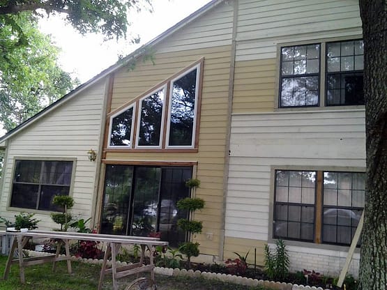A house with two windows and a table outside.