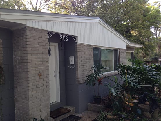 A house with a door open and a window closed.