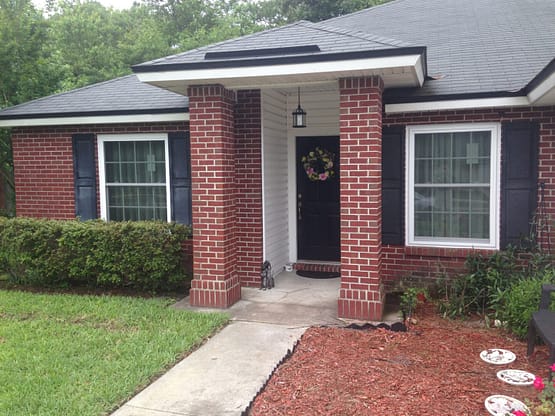 A brick house with a porch and door.