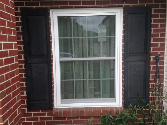 A window with shutters on the outside of a house.