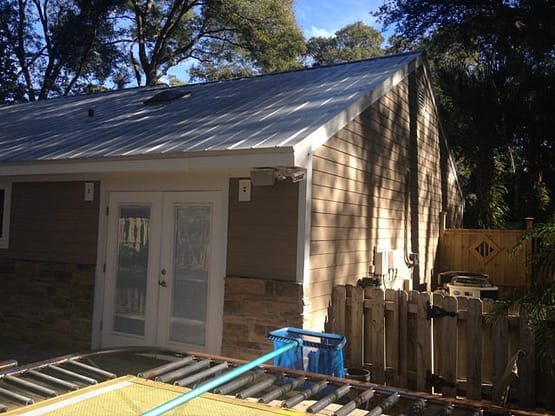 A house with a metal roof and blue door.