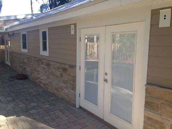 A white door and window on the side of a house.