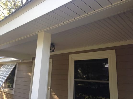 A porch with white columns and a door.