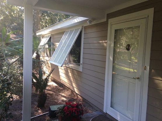 A porch with a white door and a window.