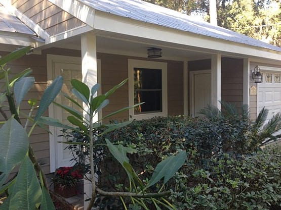 A house with plants and bushes in front of it.