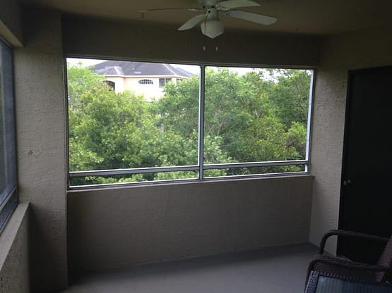 A room with a large window and trees outside.