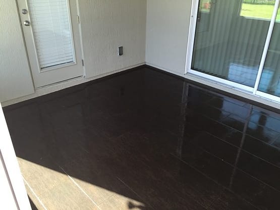 A room with dark brown floor and white walls.