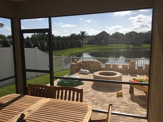 A patio with a fire pit and table in the middle of it.