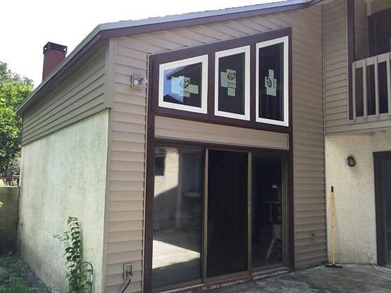 A large brown building with three windows.