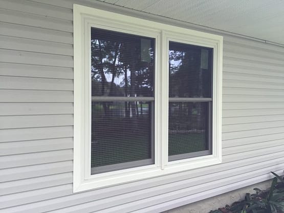 A white window with two windows on the outside of it.