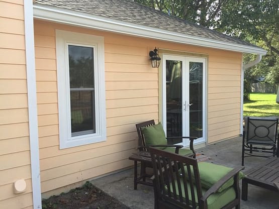 A patio with two chairs and a table outside.