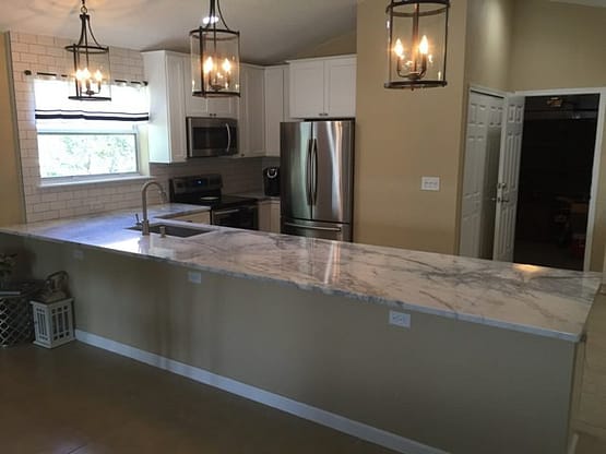 A kitchen with a large island and stainless steel appliances.