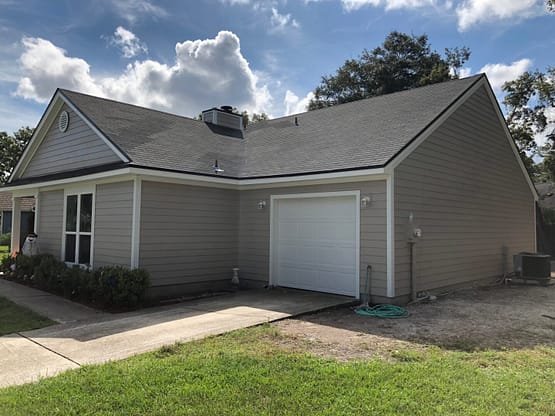 A house with a garage and driveway in front of it.