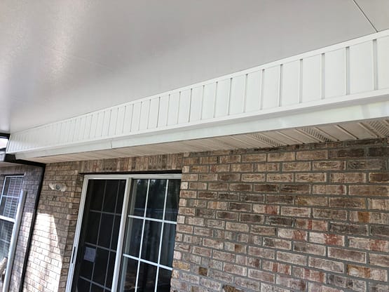 A brick wall with windows and a door.