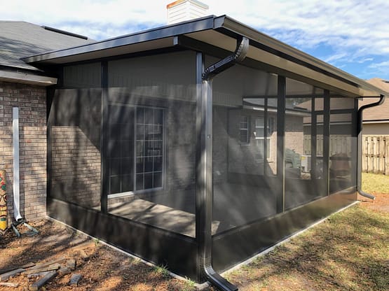 A black screen house with a metal roof.