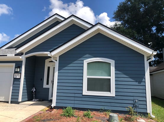 A blue house with white trim and windows.