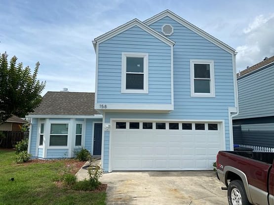 A blue house with a white garage door.