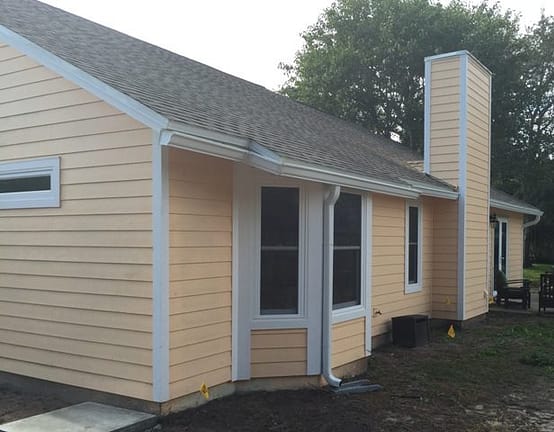 A house with yellow siding and white trim.