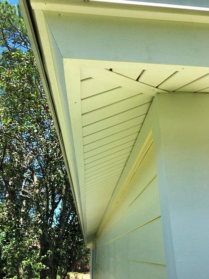 A yellow house with the door open and the window closed.