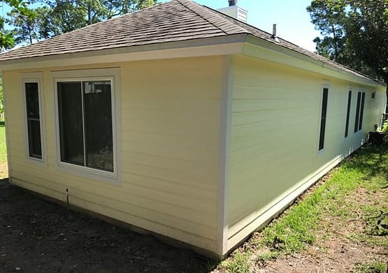 A small white building with a roof on the side.