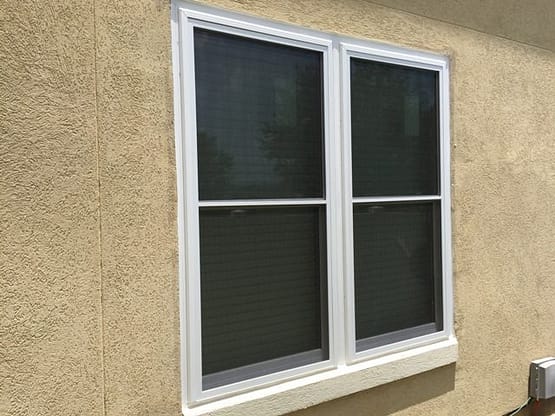 A window with two windows on the outside of a house.