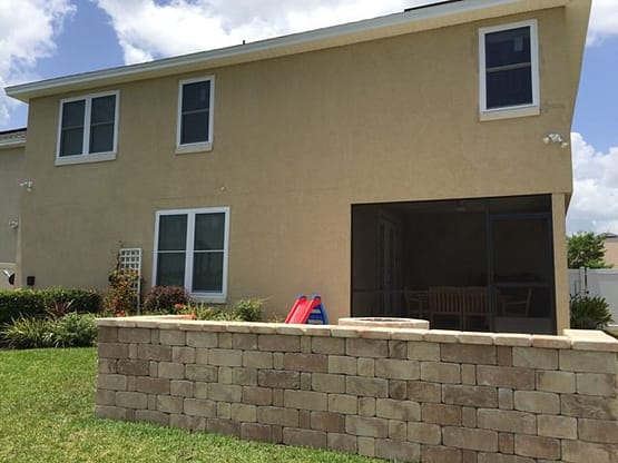A house with a brick wall and a large window.