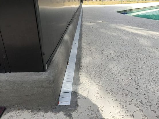 A metal door sill on the sidewalk of a street.
