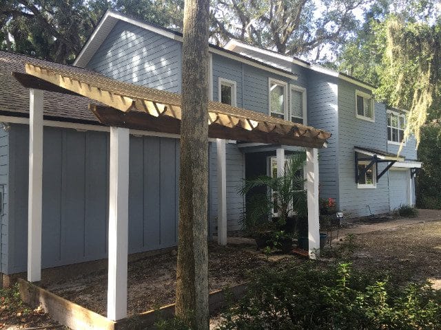 A house with a porch and trees in the background